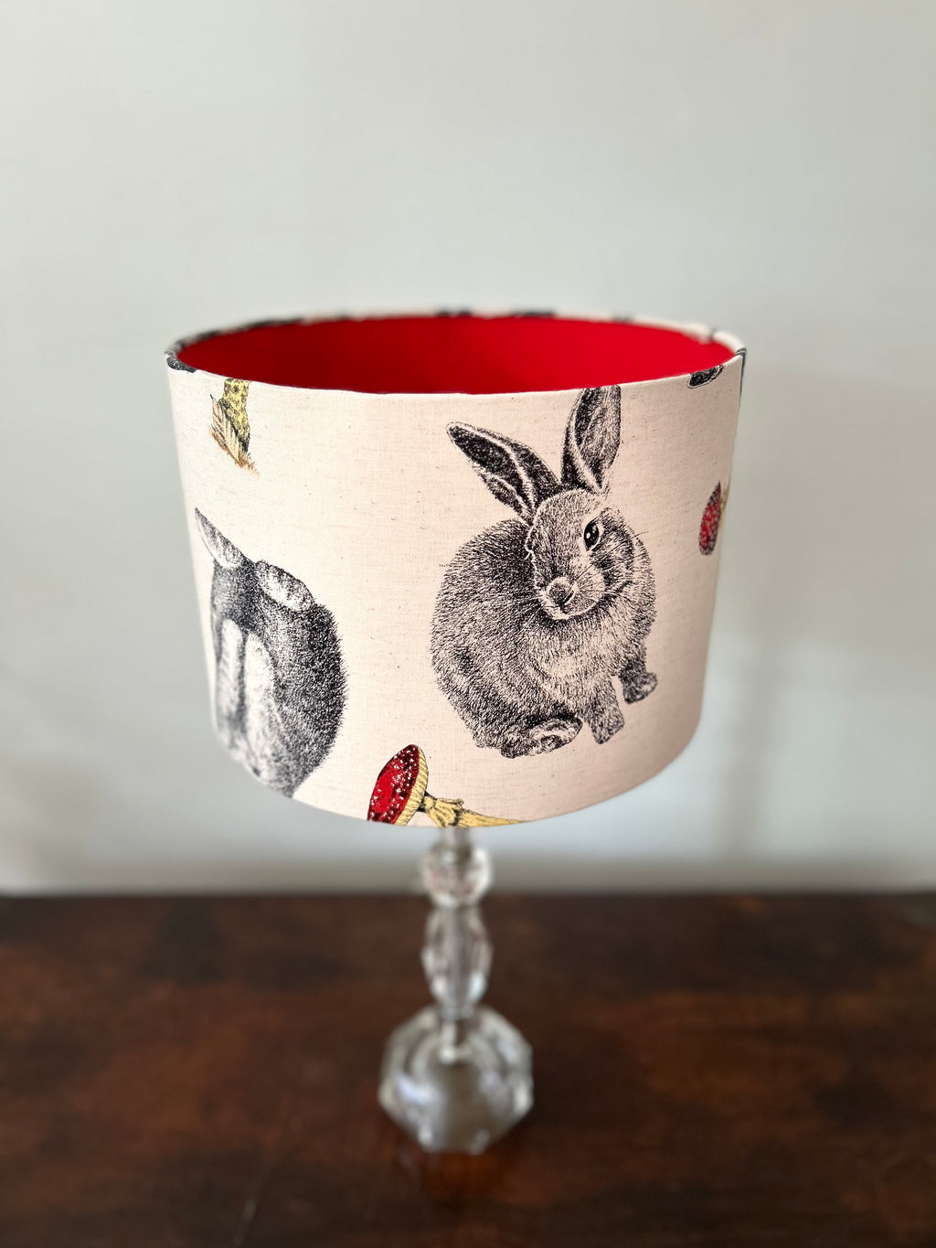 Woodland rabbit drum lampshade viewed from above, showing its red lining, detailed rabbit illustrations and red toadstools.