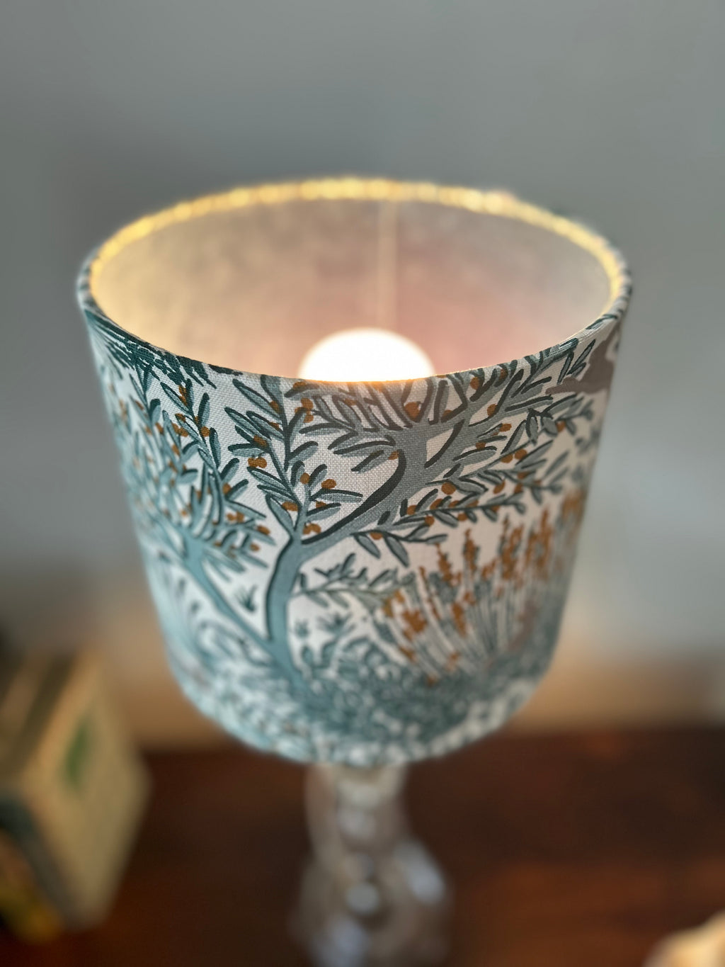 Close view of the lit rabbit-print lampshade showing its open top and softly illuminated lining.
