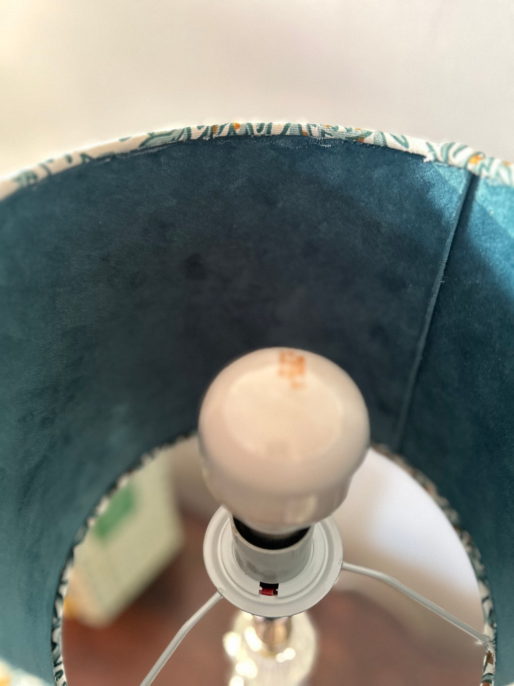 Interior view of the rabbit lampshade showing teal velvet lining, support arms and the fitting around a bulb.