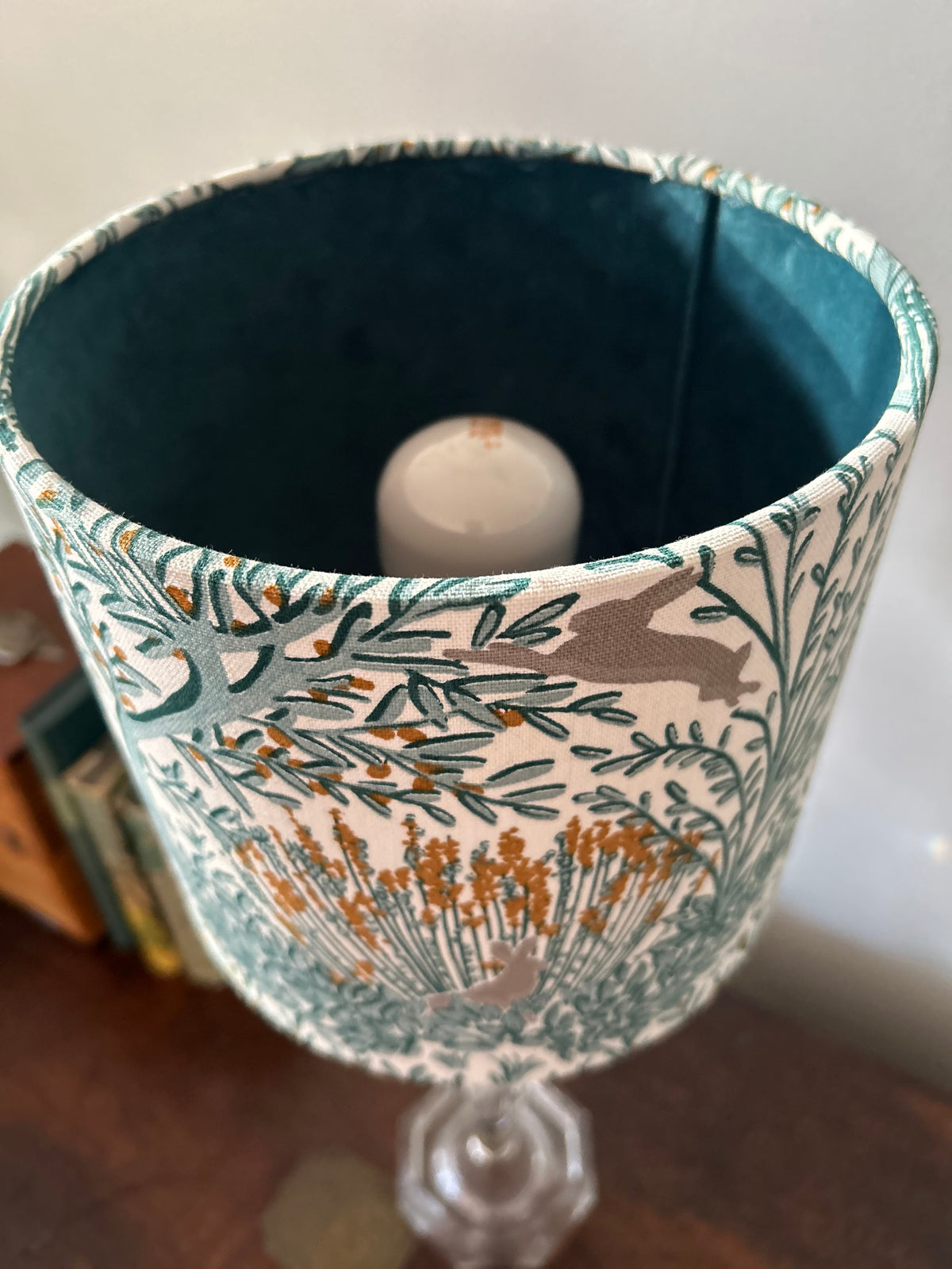 View into the woodland rabbit lampshade showing its deep teal velvet lining with the bulb switched off.